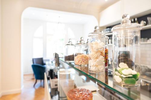 a counter with glass jars filled with different types of donuts at Strandhotel Ahlbeck in Ahlbeck