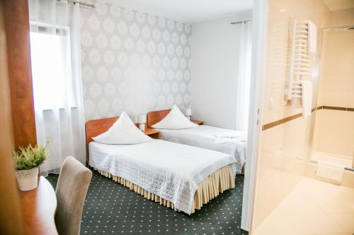 プルドニクにあるHotel Oazaのベッド2台と窓が備わる客室です。
