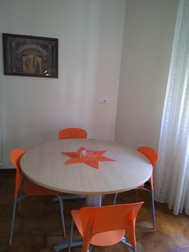 a table with four orange chairs around it at Federico's House in Ercolano