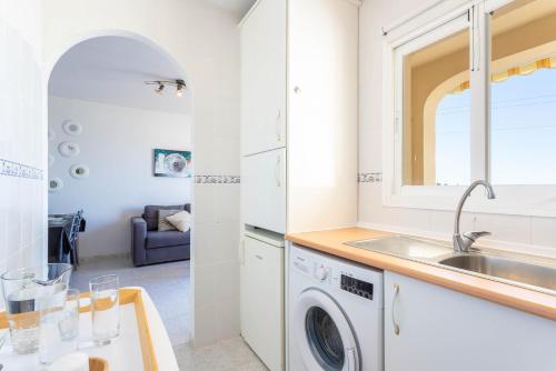 a kitchen with a sink and a washing machine at Apartamento Montesol 80 in Torrox Costa