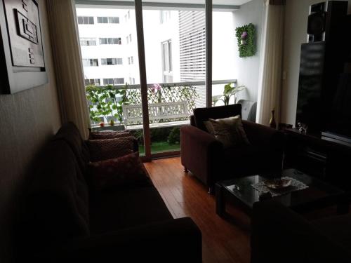 a living room with two couches and a large window at Hope San Isidro in Lima