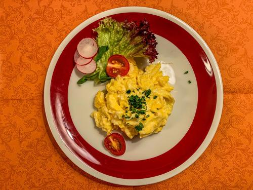 a red and white plate with eggs and vegetables on it at Hotel Post Leutkirch in Leutkirch im Allgäu