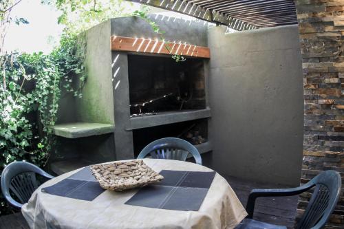 a table and chairs on a patio with a fireplace at Aloe Village Aparthotel & Spa in La Paloma