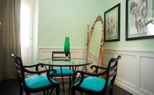 a dining room table with four chairs and a vase on it at Quel Castello di Diegaro in Cesena