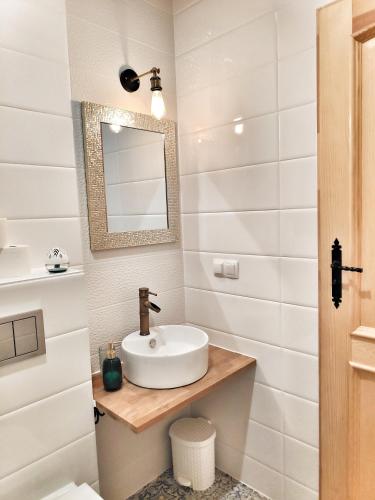 a bathroom with a sink and a mirror at Fajna Chatka in Ustrzyki Dolne