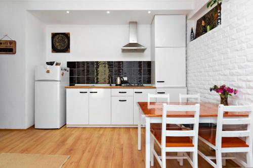 a kitchen with white cabinets and a wooden table at 31 Toidze Apartment in Tbilisi City