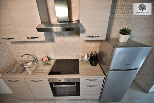 a small kitchen with a sink and a refrigerator at La VILLA in Modugno