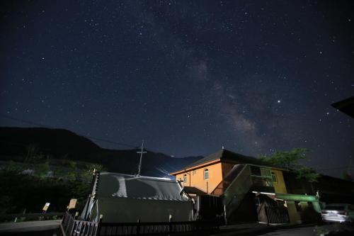 a house under a starry sky at night at Daegwanryeong Egg Guesthouse in Pyeongchang
