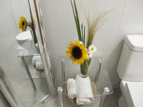 a bathroom with a vase with flowers in it at Cabañas Lemupewen Chillán 2 Factura in Chillán
