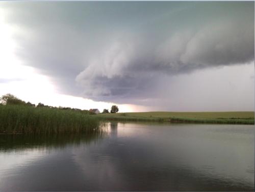 a storm cloud over a body of water at Fajne Miejsce in Jeziorany