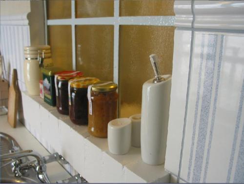 a shelf with jars and a toothbrush on a counter at Fajne Miejsce in Jeziorany