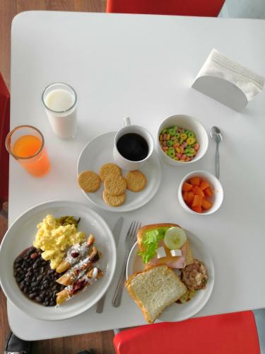 a white table topped with plates of breakfast foods at Hotel Block Suites in Mexico City