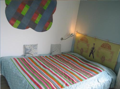a bedroom with a bed with a colorful striped blanket at Fajne Miejsce in Jeziorany