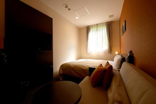 a hotel room with two beds and a window at Aridagawa Onsen Hotel Sunshine in Arida