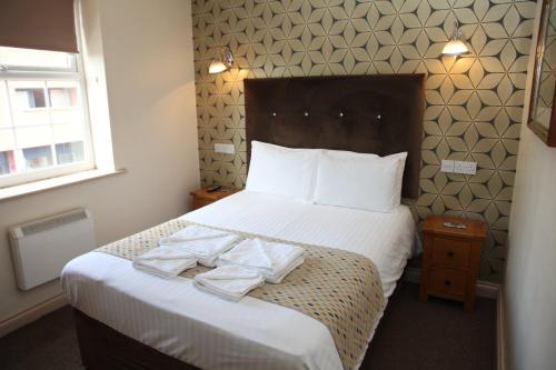 Una habitación de hotel con una cama con toallas. en The Moseley Arms en Birmingham