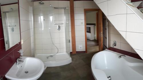 ein Badezimmer mit 2 Waschbecken, einer Badewanne und einem Spiegel in der Unterkunft Apartmán Lidická in Vracov