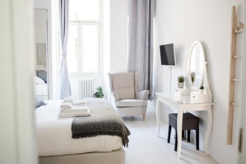 biała sypialnia z łóżkiem, biurkiem i lustrem w obiekcie White Fanti Apartment w Rzymie