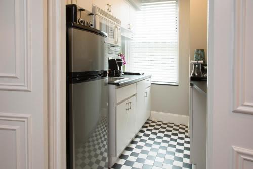 a kitchen with a black refrigerator and a checkered floor at The Sherry Netherland in New York