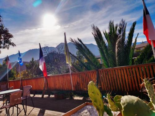 a deck with flags and a table and chairs at Hostal Michel in Vicuña