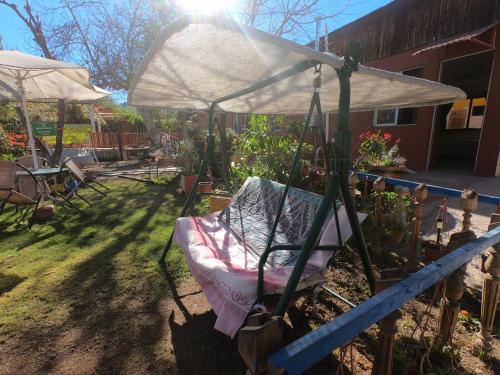 a swinging chair under an umbrella in a yard at Hostal Michel in Vicuña