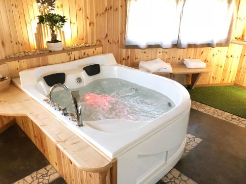 y baño de madera con bañera blanca grande. en REnt Room Wood en Anguillara Sabazia