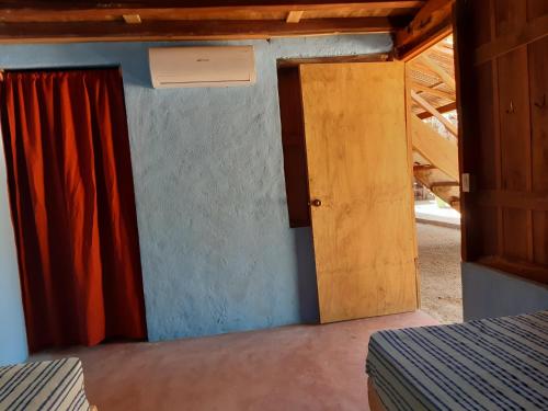 a room with a bed and a door at Cabañas jaysur in Barra de la Cruz