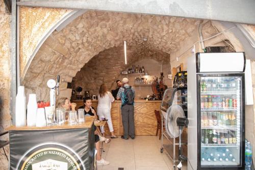 a group of people standing at a bar in a store at La Casetta in Nazareth