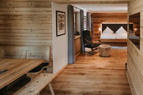 Zimmer mit Holzwänden, einem Bett und einem Schreibtisch in der Unterkunft Tegernseer Hof in Gmund am Tegernsee