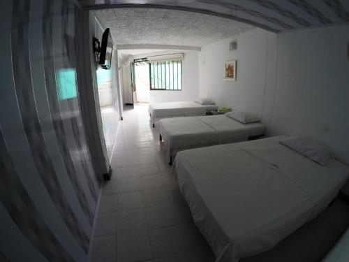 a room with two beds and a hallway with two windows at Sky Club Eco Hotel in Belén de Umbría