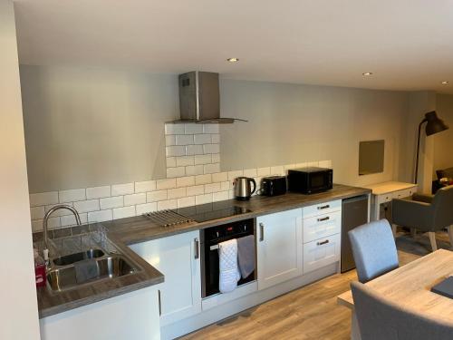 a kitchen with a sink and a counter top at Fornham Guest House in Chertsey