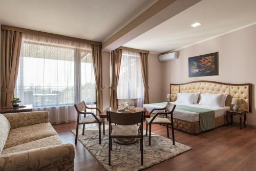 Habitación de hotel con cama, mesa y sillas en Hotel Villa Magus, en Kladnitsa
