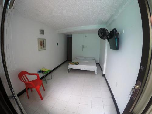 a room with a bed and a red chair at Sky Club Eco Hotel in Belén de Umbría