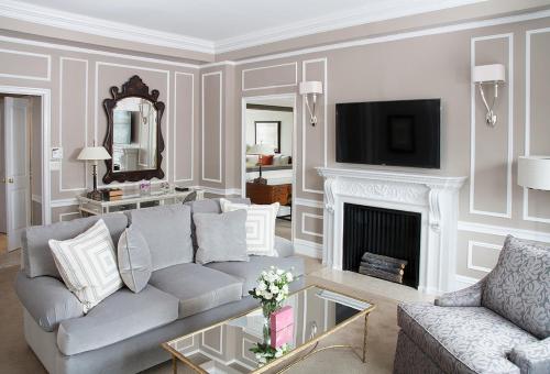a living room with a couch and a fireplace at The Sherry Netherland in New York