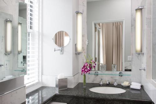 a bathroom with a sink with a vase of flowers at The Sherry Netherland in New York
