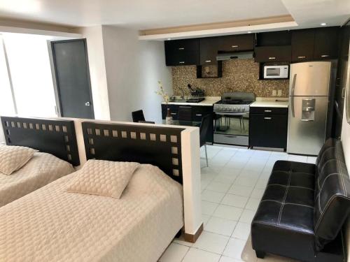 a bedroom with two beds and a kitchen with a stove at Hotel acapulco y suites mediterrane in Acapulco