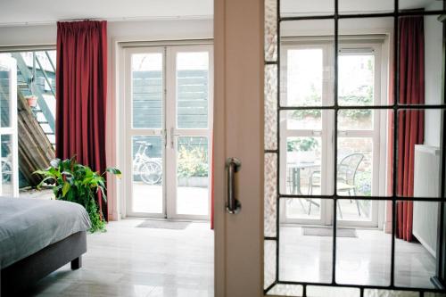 a bedroom with a door open to a balcony at Suite 30 - OvernachteninStijl in Groningen