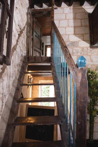 a wooden staircase in a building with a blue railing at La Casetta in Nazareth