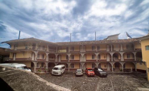 a large building with cars parked in front of it at Hotel del Rio in Orizaba