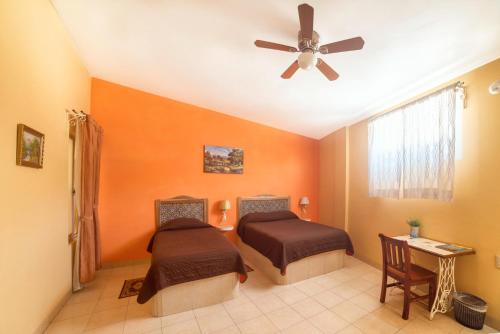 een slaapkamer met 2 bedden en een plafondventilator bij Hotel del Rio in Orizaba