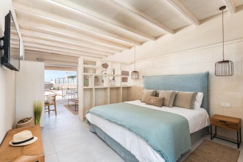 a bedroom with a blue bed and a balcony at Agroturismo Llucasaldent Gran Menorca - Adults Only in Son Bou