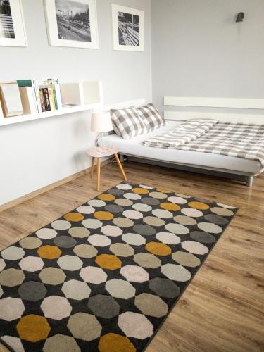 a bedroom with a bed and a rug on the floor at Apartament Kotwica in Gdynia