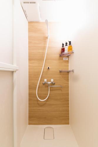 a shower in a bathroom with a hose on the floor at eni minamihorie Kaede in Osaka