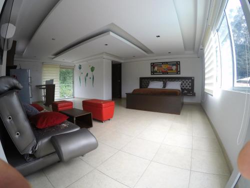 a bedroom with a bed and a couch and a chair at Sky Club Eco Hotel in Belén de Umbría