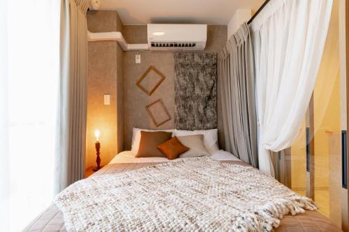 a bedroom with a large bed with a large window at eni minamihorie Kaede in Osaka