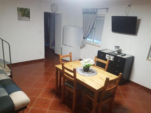 Casa dos Avós e Netos في فانداو: مطبخ وغرفة طعام مع طاولة وكراسي خشبية