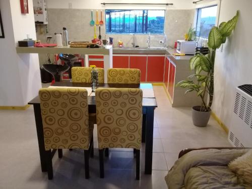 uma cozinha com mesa e cadeiras num quarto em Javis House em El Calafate