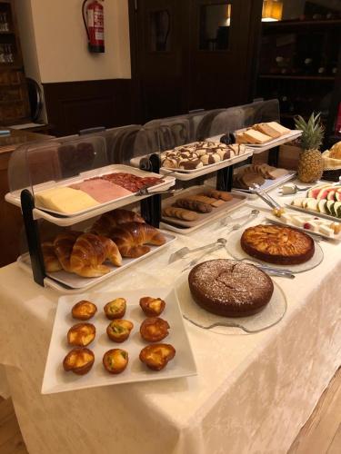 a table with many different types of pastries and cakes at Hotel Los Cigarrales in Toledo