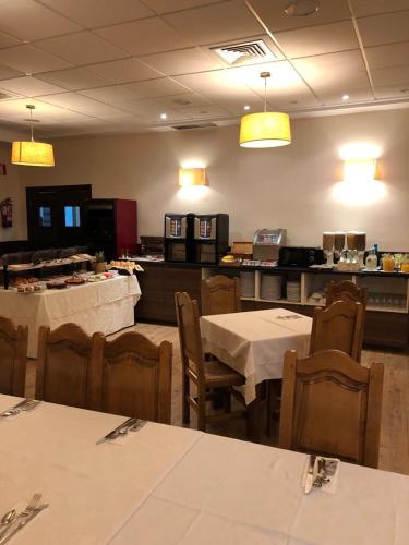 a dining room with tables and chairs and a restaurant at Hotel Los Cigarrales in Toledo
