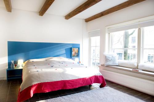 Un dormitorio con una cama grande y una ventana en Jackie O Studio en Ámsterdam