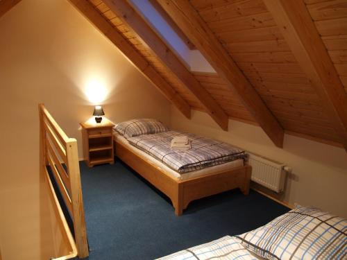 a bedroom with two beds and a night stand in a attic at Penzion Vital in Liberec